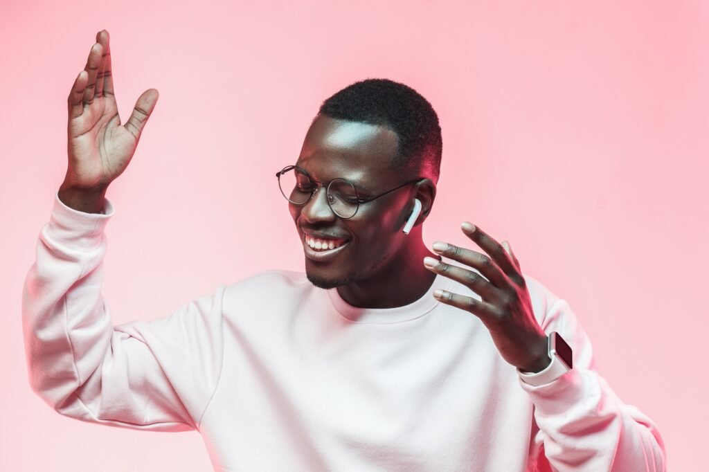 Dancing young african man listening to music with earphones