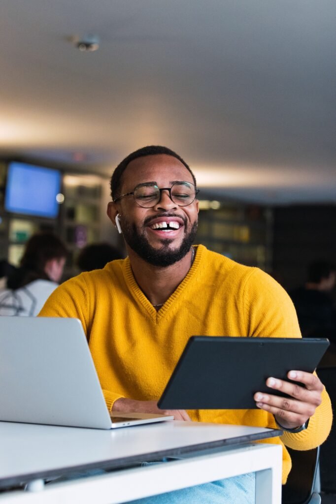 Smiling young African student working on a tablet in university